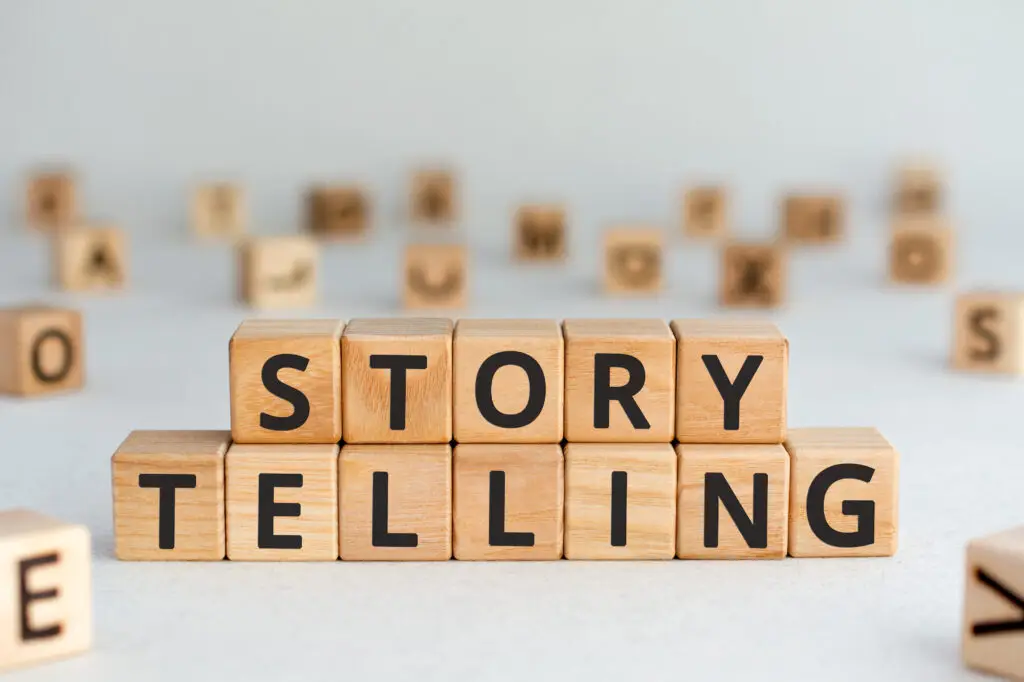 story telling - words from wooden blocks with letters, the art of telling stories storytelling concept, random letters around, white background